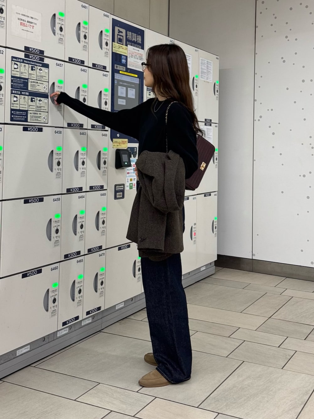 ブラウン系のテーラードジャケット、ブラック系のニット/セーター、ブルー系のデニムパンツを着用したレディースの秋コーディネートの7枚目の写真