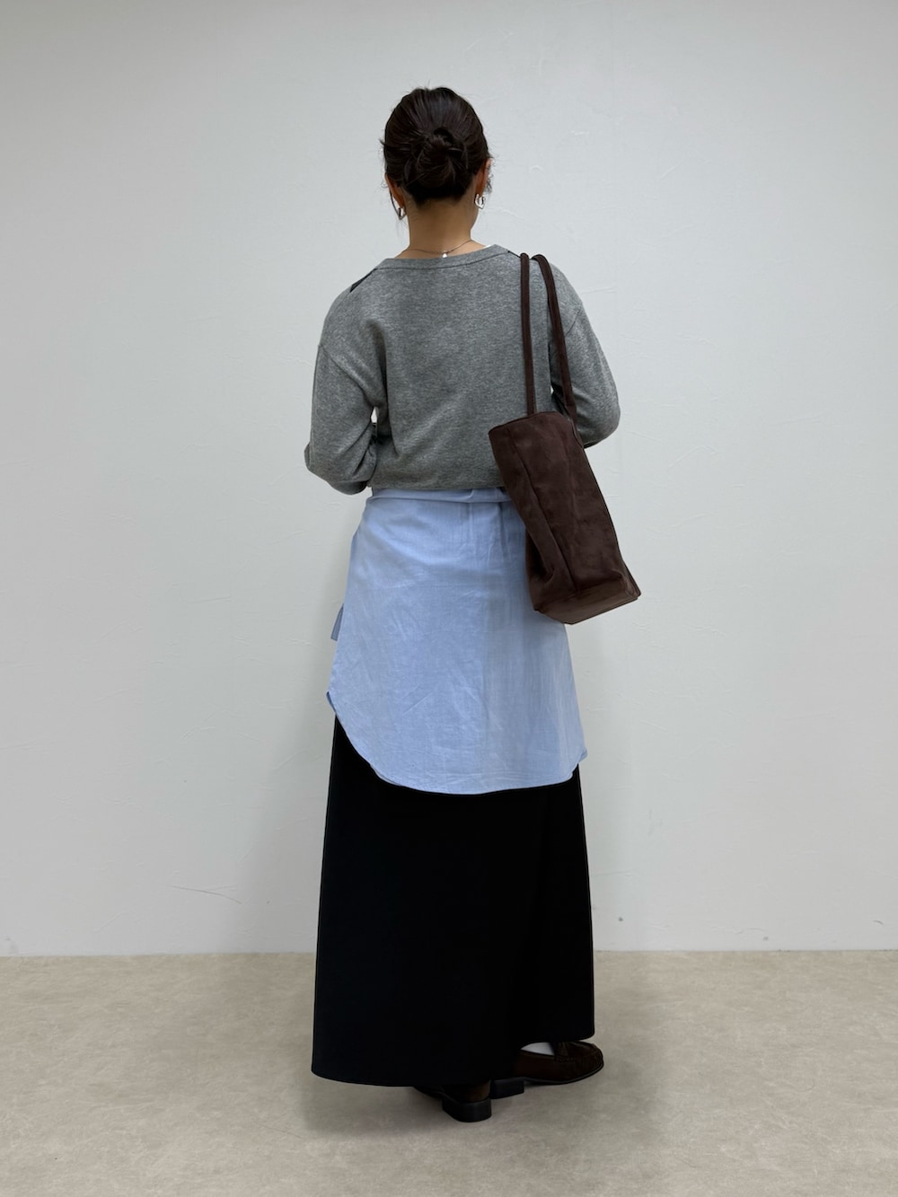 グレー系のニット/セーター、ブラック系のスカートを着用したレディースの冬コーディネートの4枚目の写真