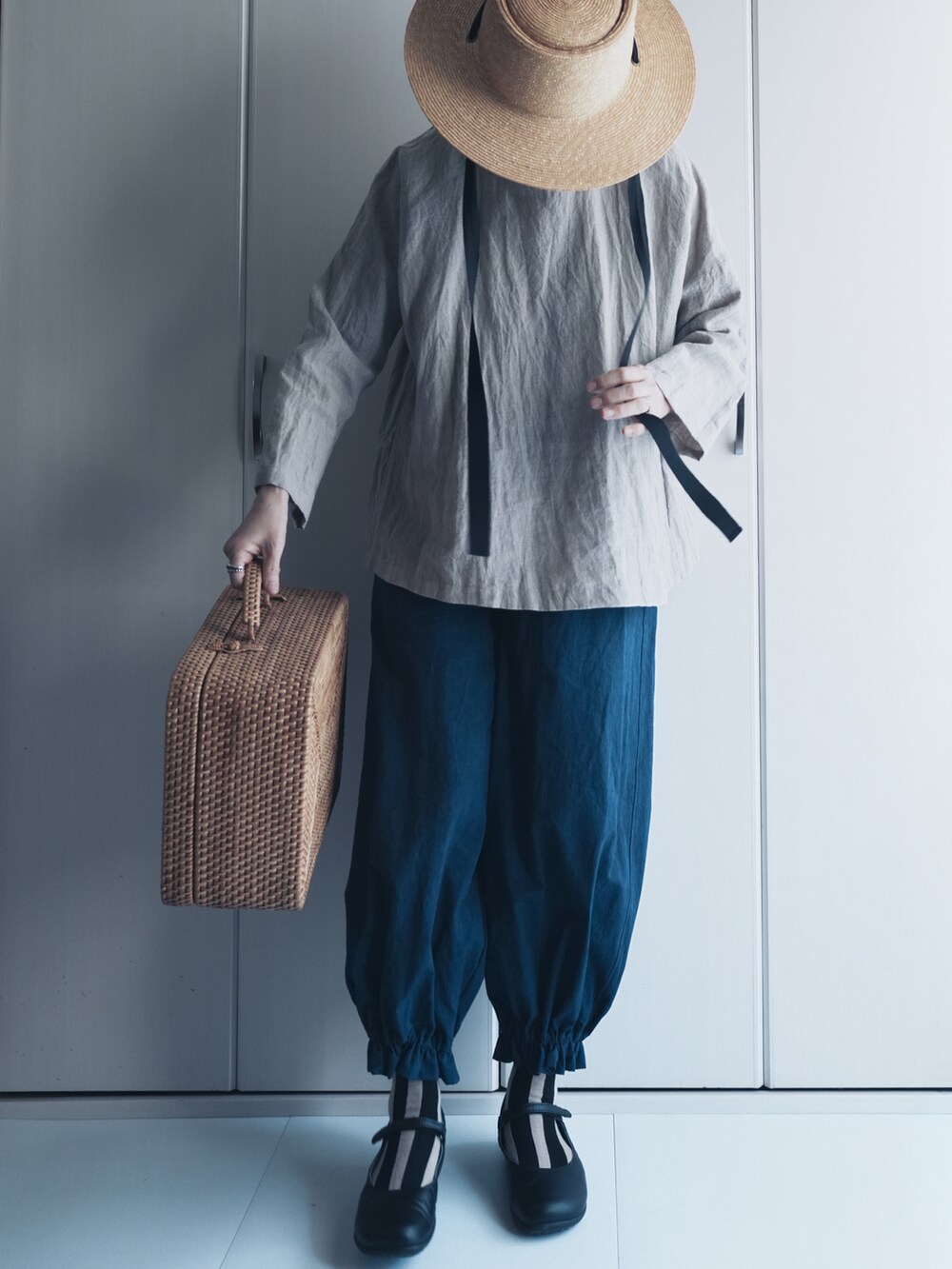 ブルー系のパンツ、ベージュ系のハットを着用したレディースの夏コーディネートの3枚目の写真