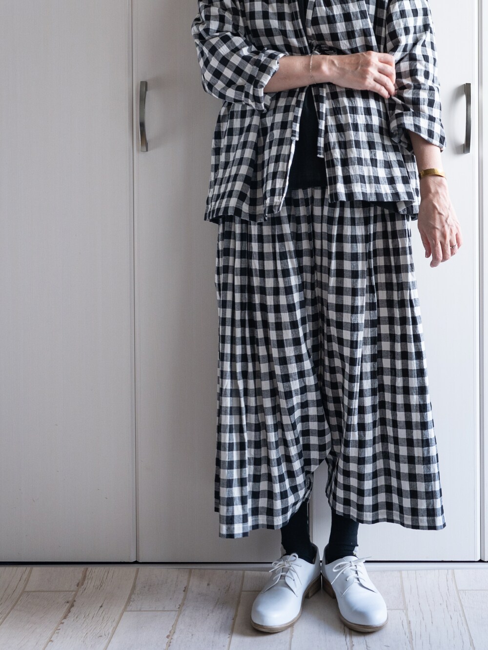 ホワイト系のドレスシューズ、ブラック系のシャツ/ブラウス、ブラック系のその他パンツを着用したレディースの秋コーディネートの5枚目の写真