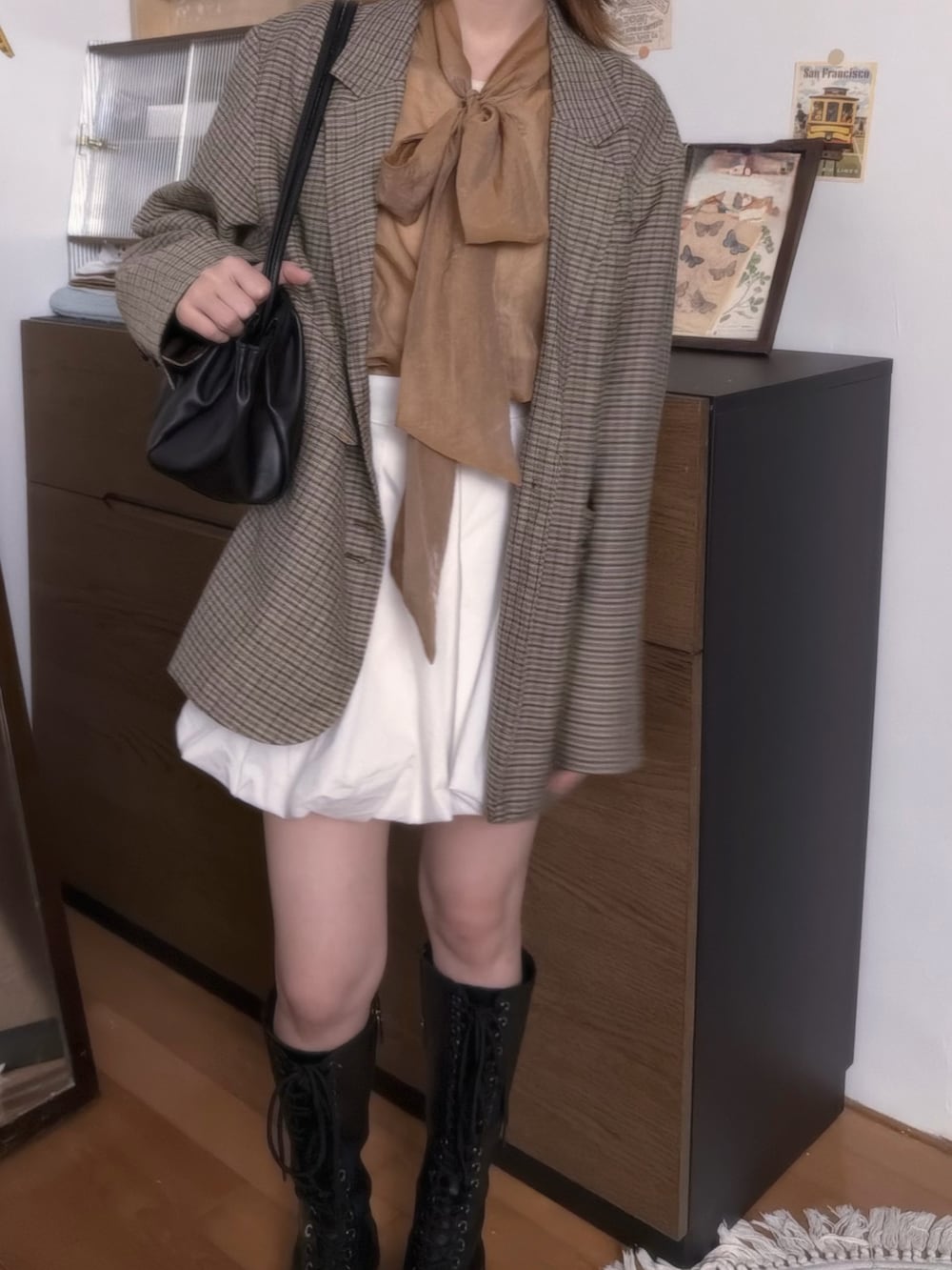 ブラウン系のシャツ/ブラウス、ホワイト系のスカート、ブラック系のブーツを着用したレディースの夏コーディネートの2枚目の写真