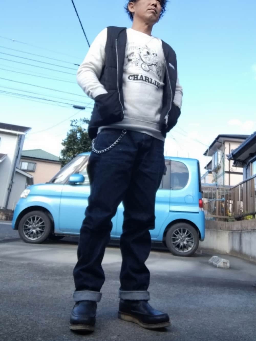 ブラック系のブーツ、ブルー系のデニムパンツ、ブラック系のベストを着用したメンズの冬コーディネートの2枚目の写真