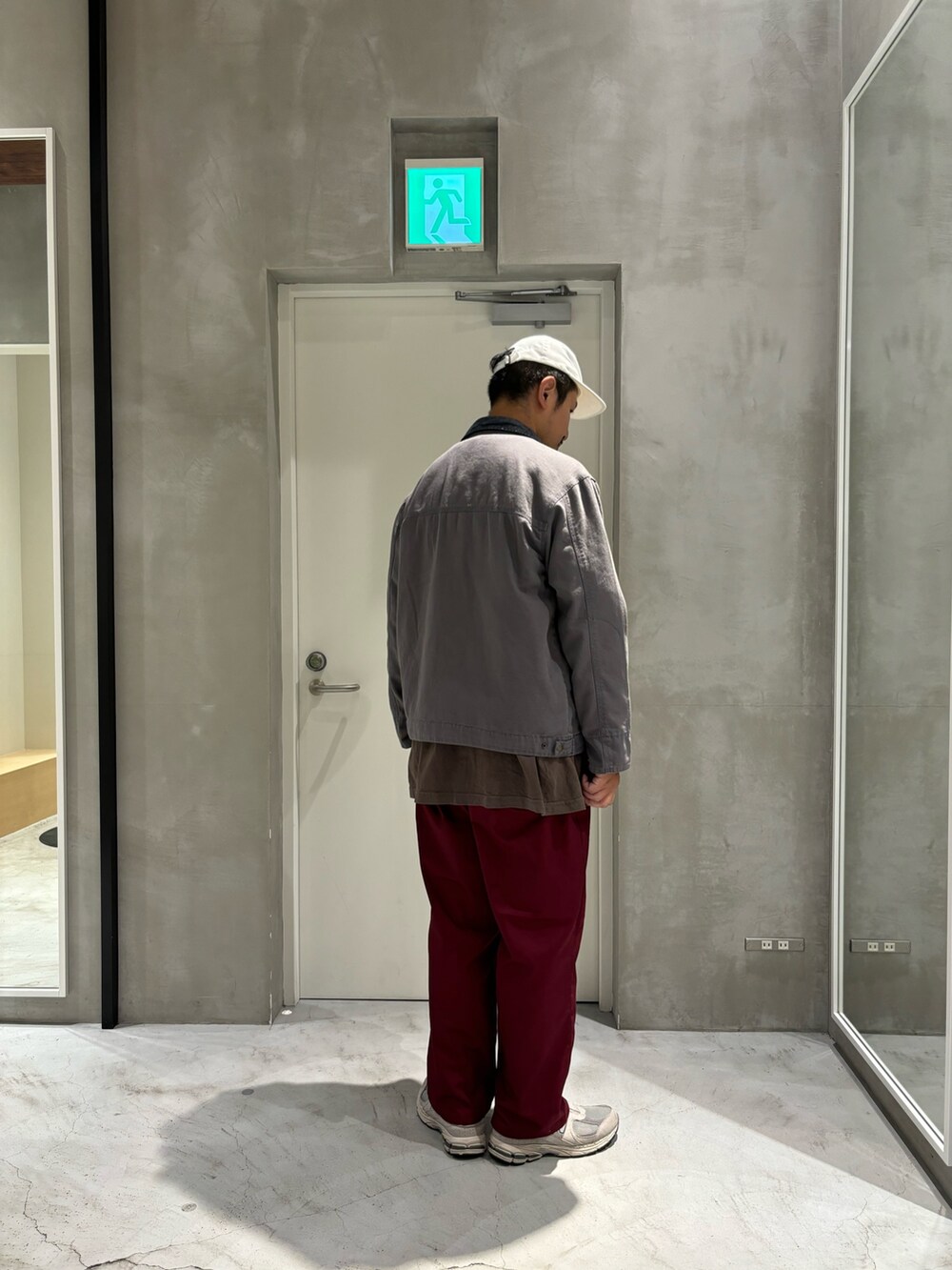 ブラック系のブルゾン、レッド系のチノパンツを着用したメンズの秋コーディネートの3枚目の写真