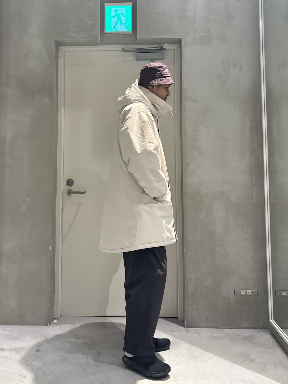 ホワイト系のダウンジャケット/コート、グレー系のスラックスを着用したメンズの冬コーディネートの2枚目の写真