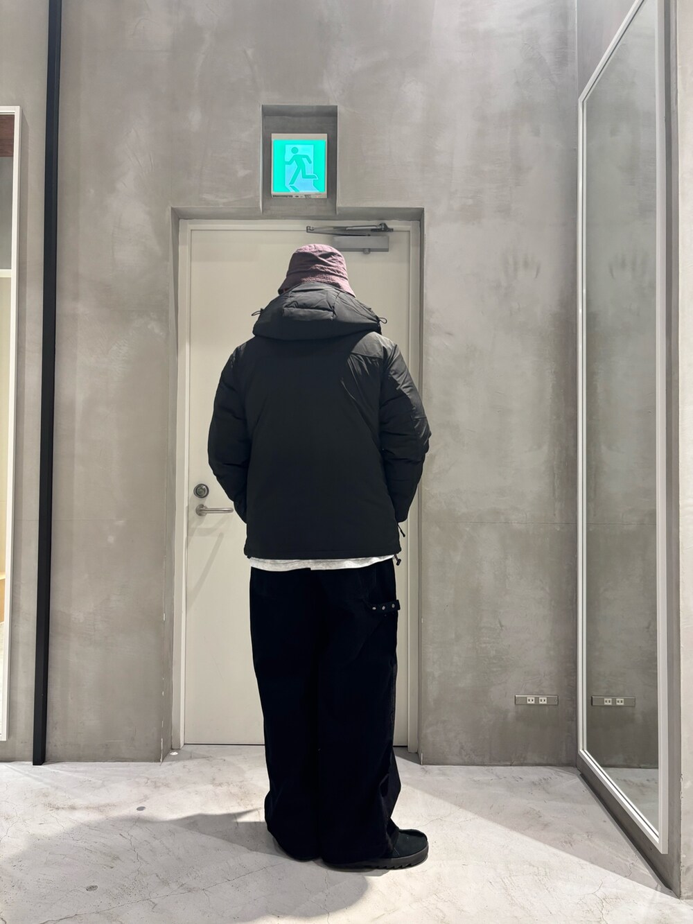 ブラック系のダウンジャケット/コート、ブラック系のその他パンツを着用したメンズの冬コーディネートの2枚目の写真