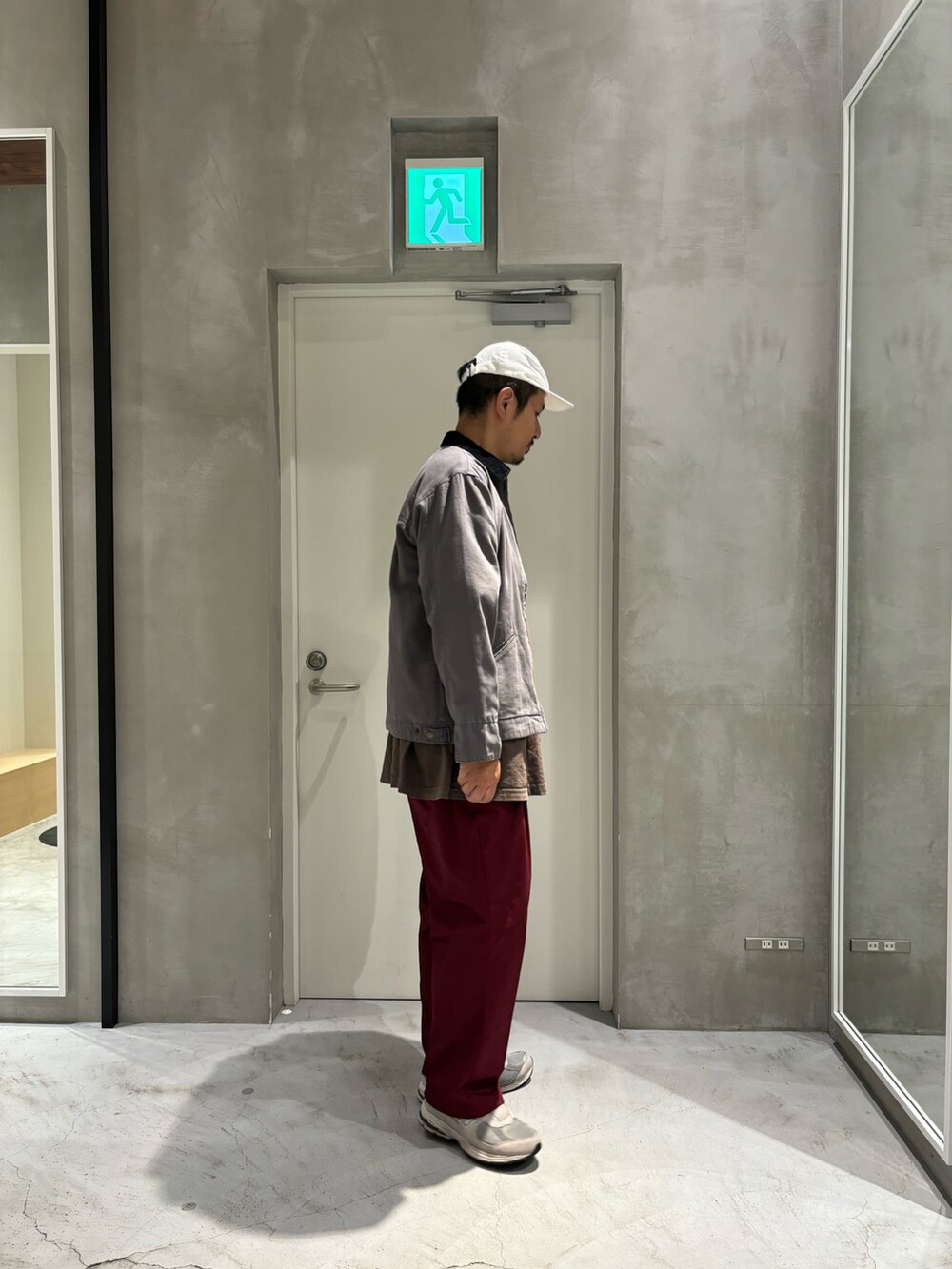 ブラック系のブルゾン、レッド系のチノパンツを着用したメンズの秋コーディネートの2枚目の写真