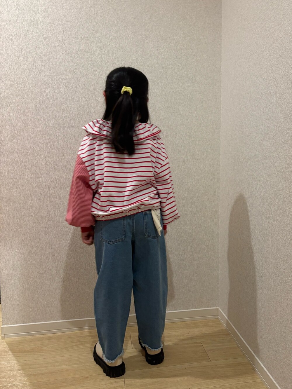 レッド系のTシャツ/カットソー、ブルー系のデニムパンツを着用したキッズの春コーディネートの2枚目の写真