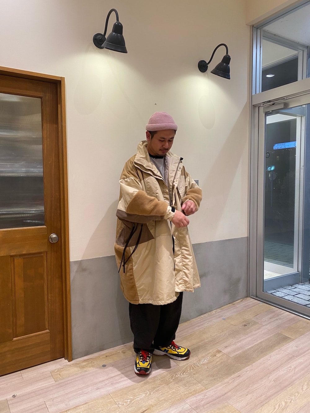 イエロー系のダウンジャケット/コート、グレー系のTシャツ/カットソー、ピンク系のニットキャップ/ビーニーを着用したメンズの冬コーディネートの2枚目の写真
