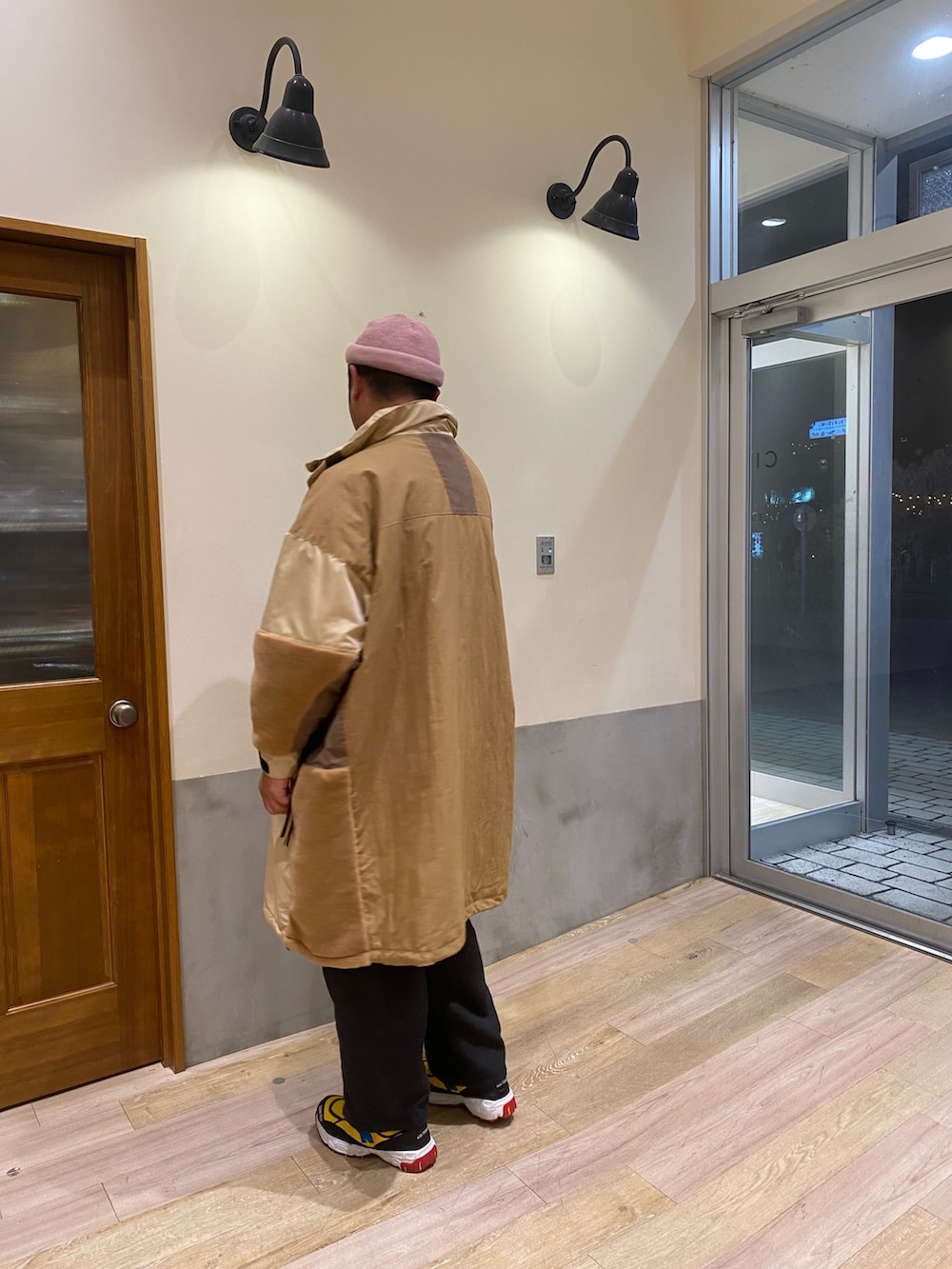 イエロー系のダウンジャケット/コート、グレー系のTシャツ/カットソー、ピンク系のニットキャップ/ビーニーを着用したメンズの冬コーディネートの3枚目の写真