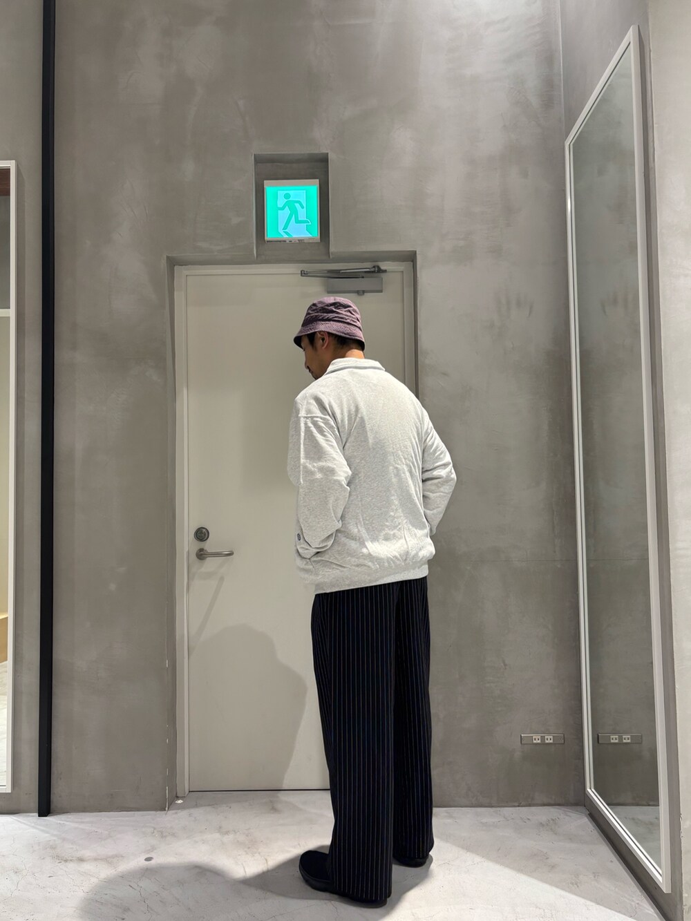 グレー系のスウェット、ブラック系のスラックスを着用したメンズの秋コーディネートの2枚目の写真