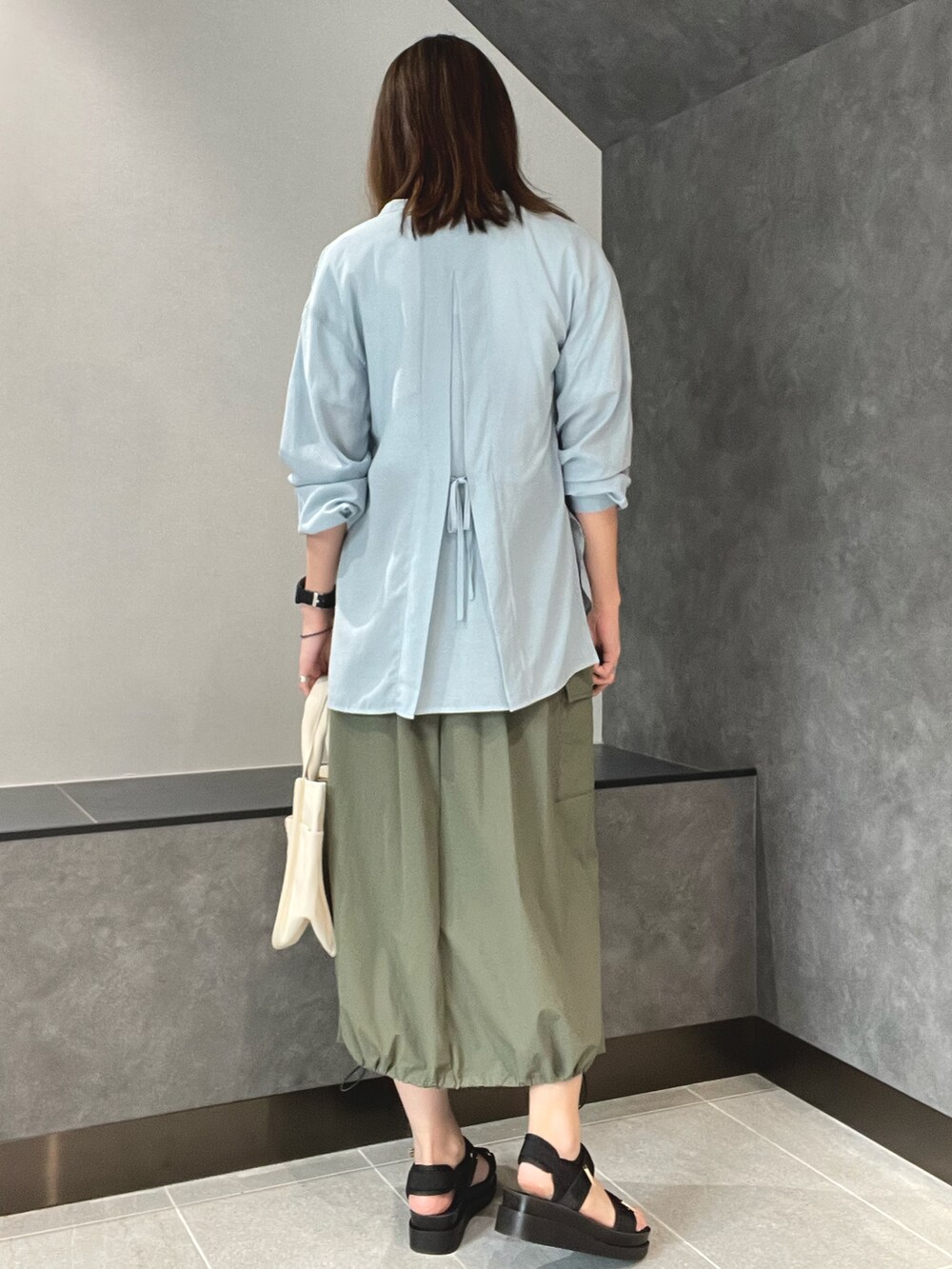 ホワイト系のTシャツ/カットソー、ブルー系のシャツ/ブラウス、グリーン系のスカートを着用したレディースの春コーディネートの2枚目の写真