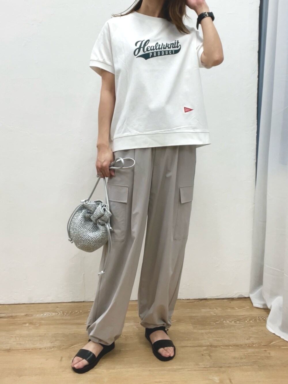 ホワイト系のTシャツ/カットソー、シルバー系のショルダーバッグ、ブラック系のサンダルを着用したレディースの春コーディネートの2枚目の写真