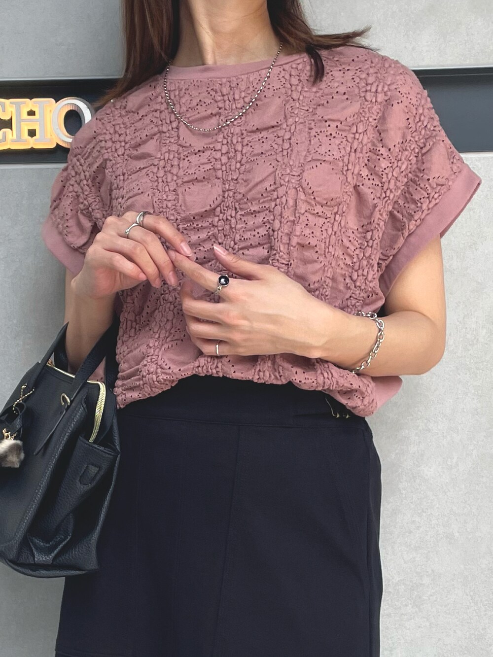 ブラック系のボストンバッグ、ブラック系のサンダル、ピンク系のTシャツ/カットソーを着用したレディースの夏コーディネートの2枚目の写真