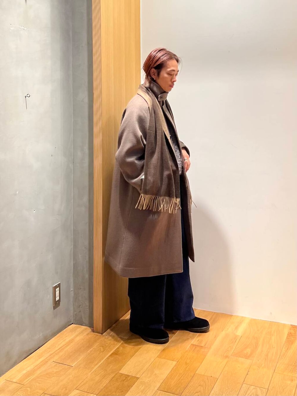 ブラウン系のステンカラーコート、ブルー系のその他パンツ、グレー系のニット/セーターを着用したメンズの冬コーディネートの2枚目の写真