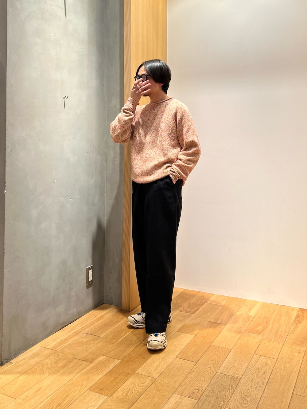 オレンジ系のニット/セーター、ブラック系のデニムパンツ、ベージュ系のスニーカーを着用したメンズの冬コーディネートの3枚目の写真