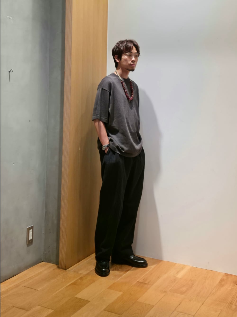 グレー系のニット/セーター、ブルー系のその他パンツ、ブラック系のドレスシューズを着用したメンズの夏コーディネートの2枚目の写真