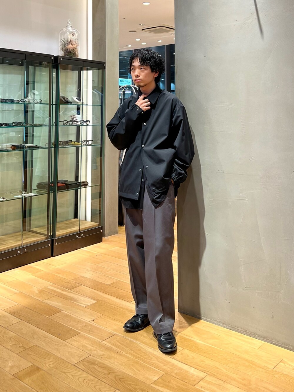 ブラック系のその他アウター、ブラック系のシャツ/ブラウス、グレー系のスラックスを着用したメンズの春コーディネートの3枚目の写真