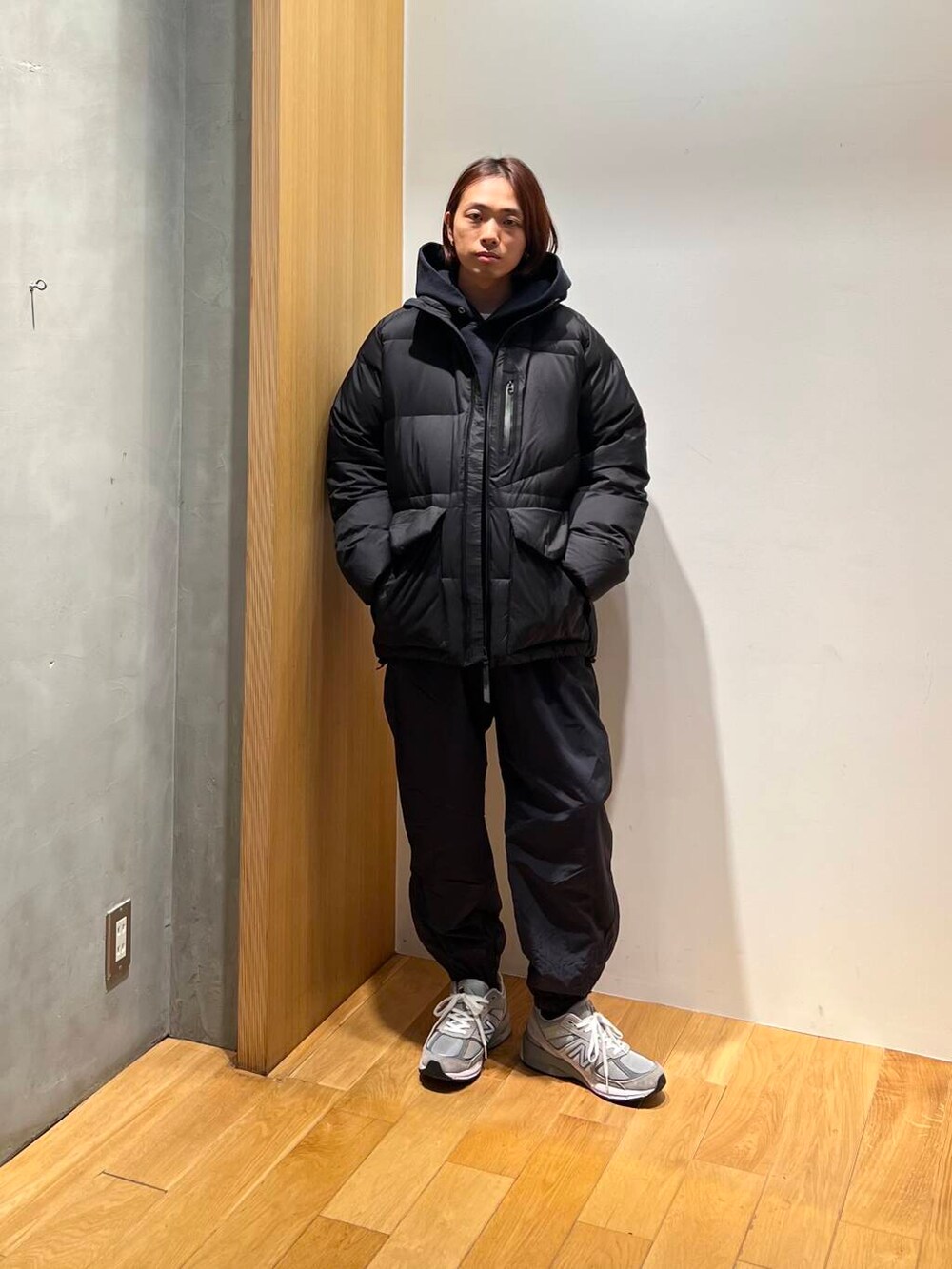 ブラック系のダウンジャケット/コート、ブルー系のパーカー、ブラック系のその他パンツを着用したメンズの冬コーディネートの2枚目の写真