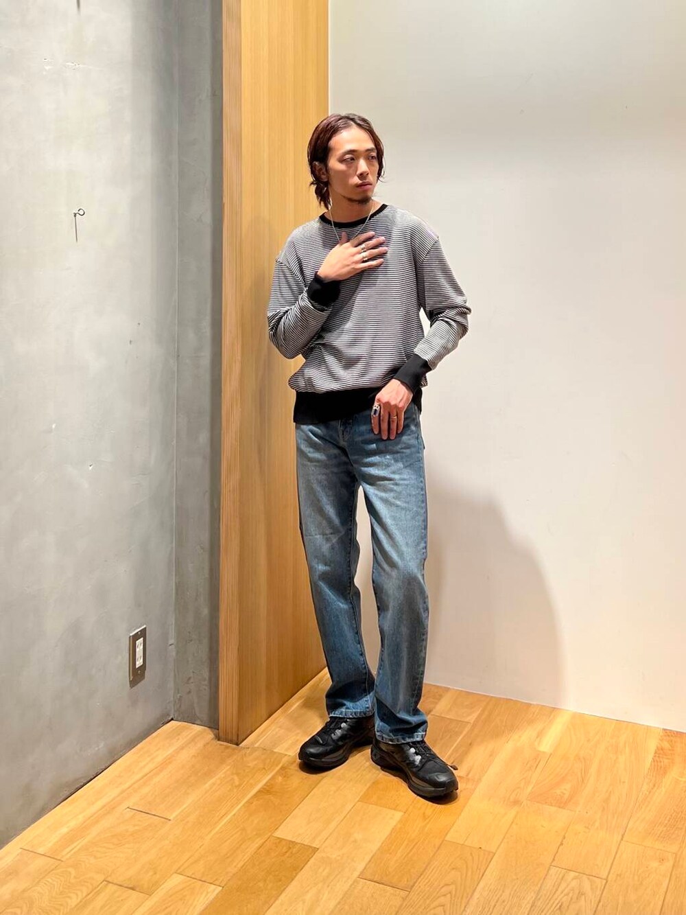 ホワイト系のニット/セーター、ブラック系のスニーカー、ブルー系のデニムパンツを着用したメンズの秋コーディネートの2枚目の写真