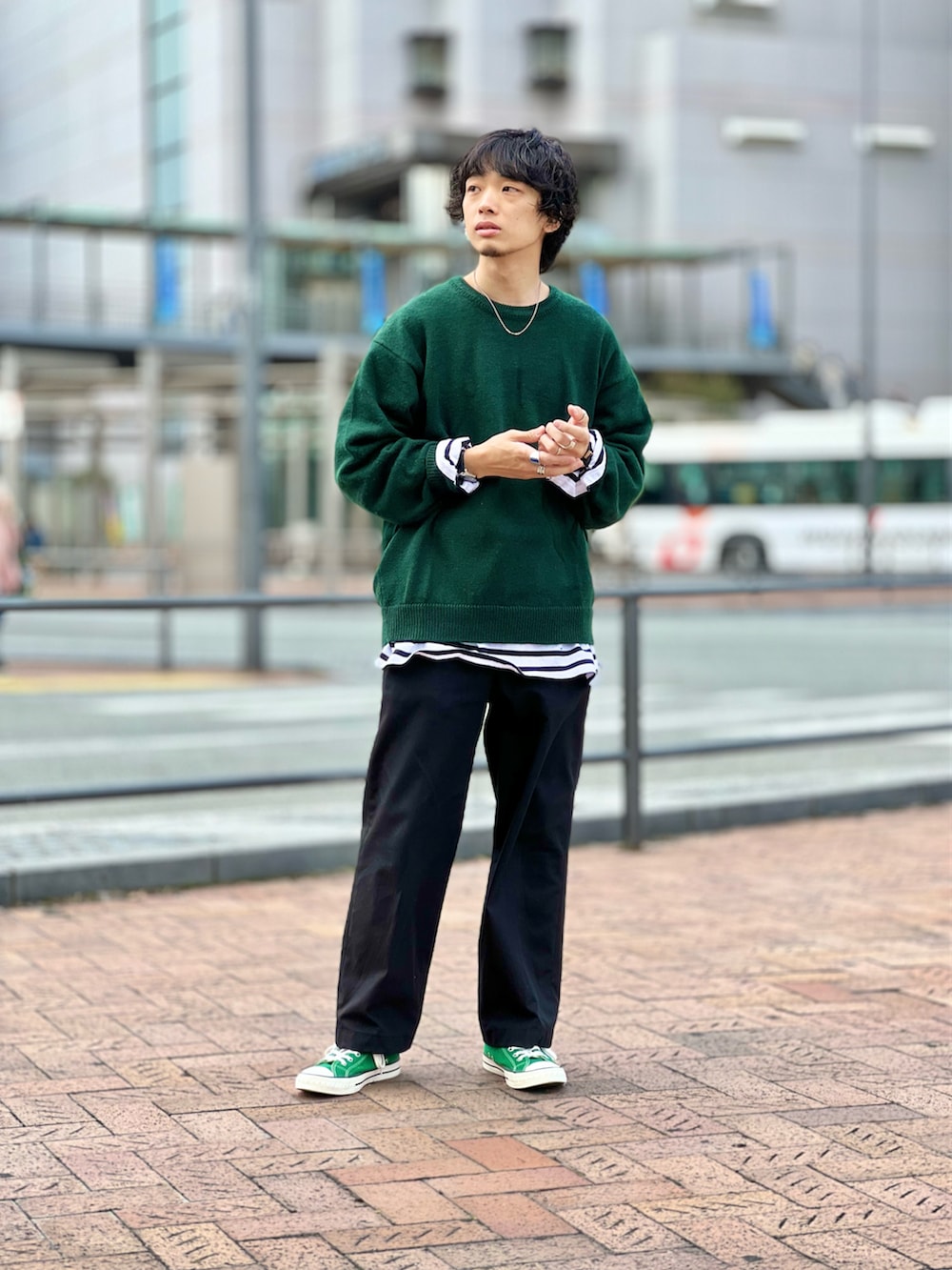 グリーン系のニット/セーター、ブラック系のTシャツ/カットソー、ブラック系のスラックスを着用したメンズの秋コーディネートの2枚目の写真