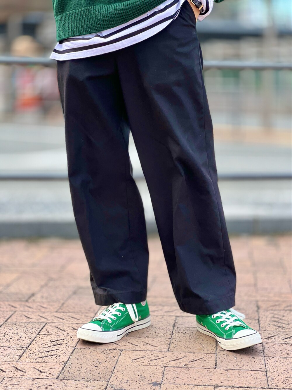グリーン系のニット/セーター、ブラック系のTシャツ/カットソー、ブラック系のスラックスを着用したメンズの秋コーディネートの4枚目の写真