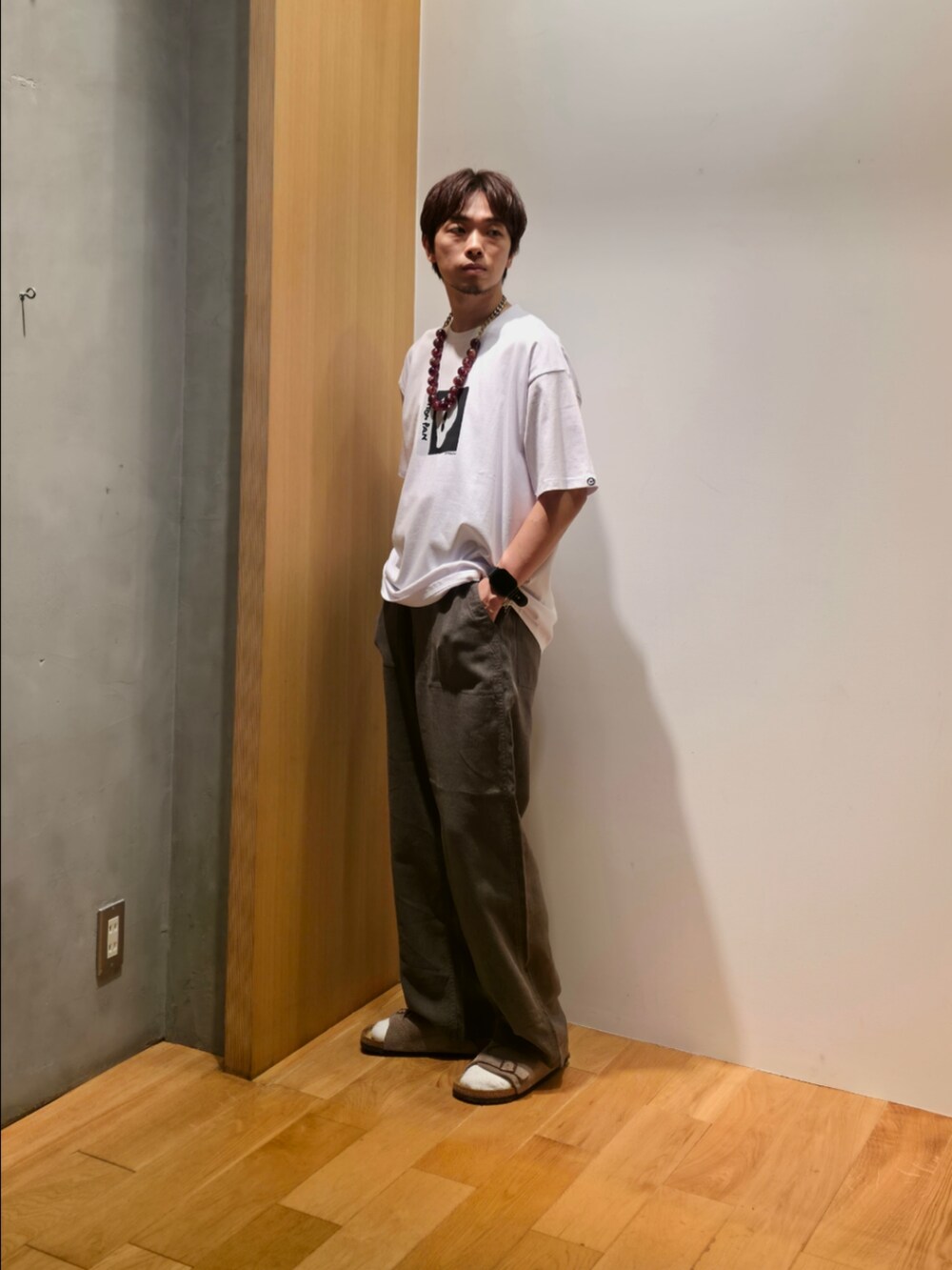 ホワイト系のTシャツ/カットソー、グレー系のその他パンツ、ベージュ系のサンダルを着用したメンズの夏コーディネートの2枚目の写真