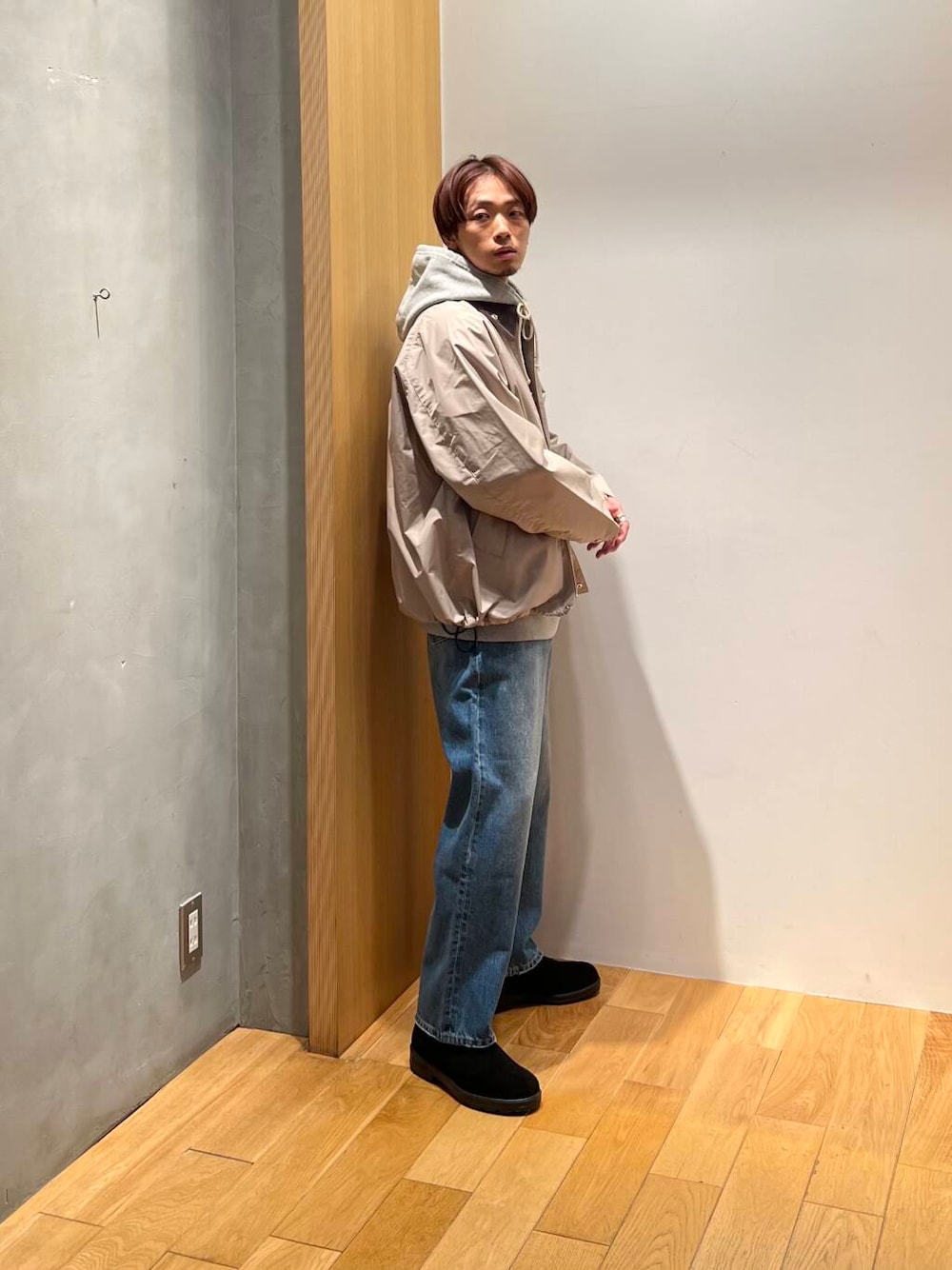 ブラック系のブーツ、ブルー系のデニムパンツ、ベージュ系のナイロンジャケットを着用したメンズの冬コーディネートの2枚目の写真