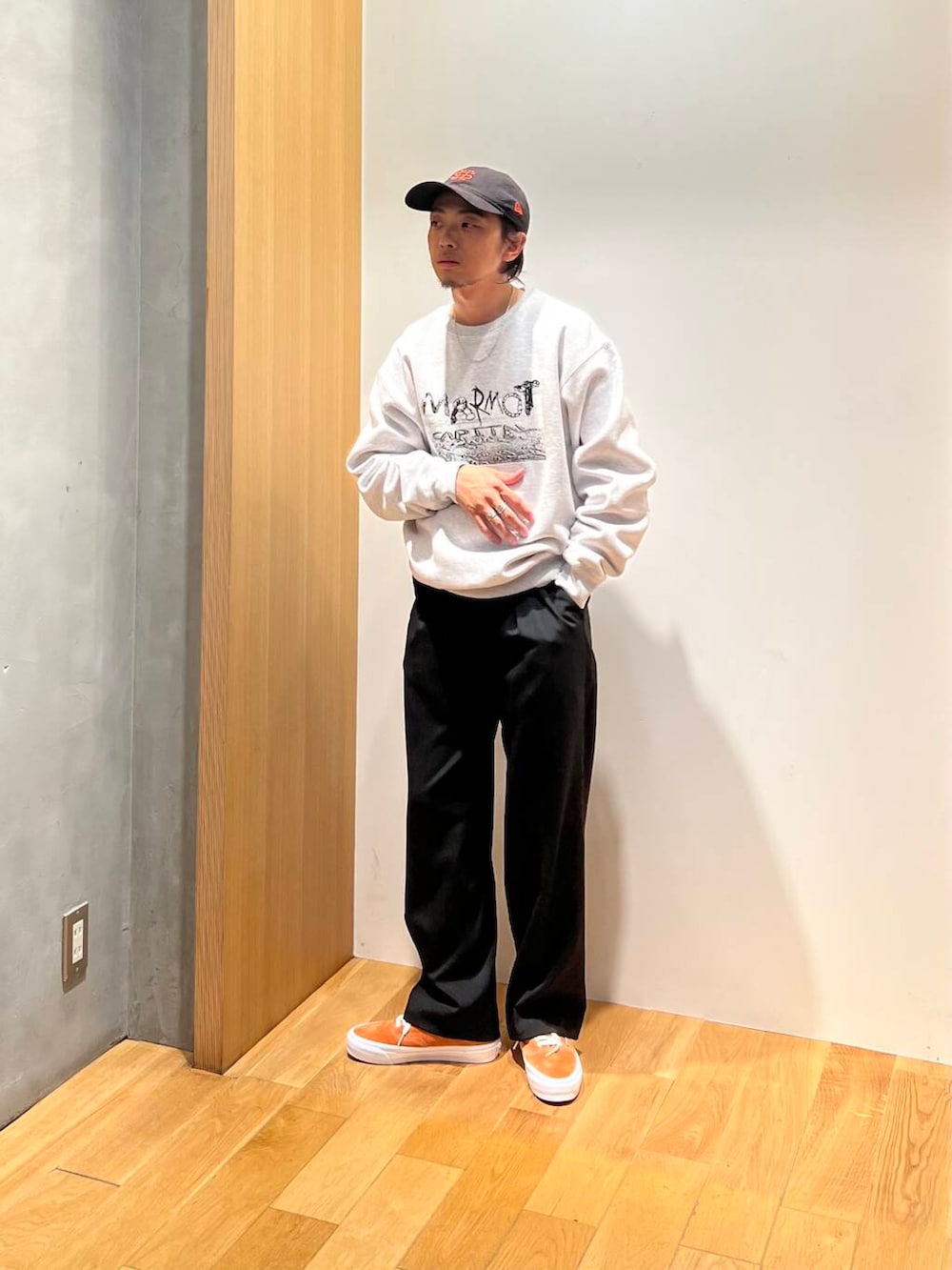 オレンジ系のスニーカー、ブラック系のスラックス、グレー系のスウェットを着用したメンズの秋コーディネートの4枚目の写真