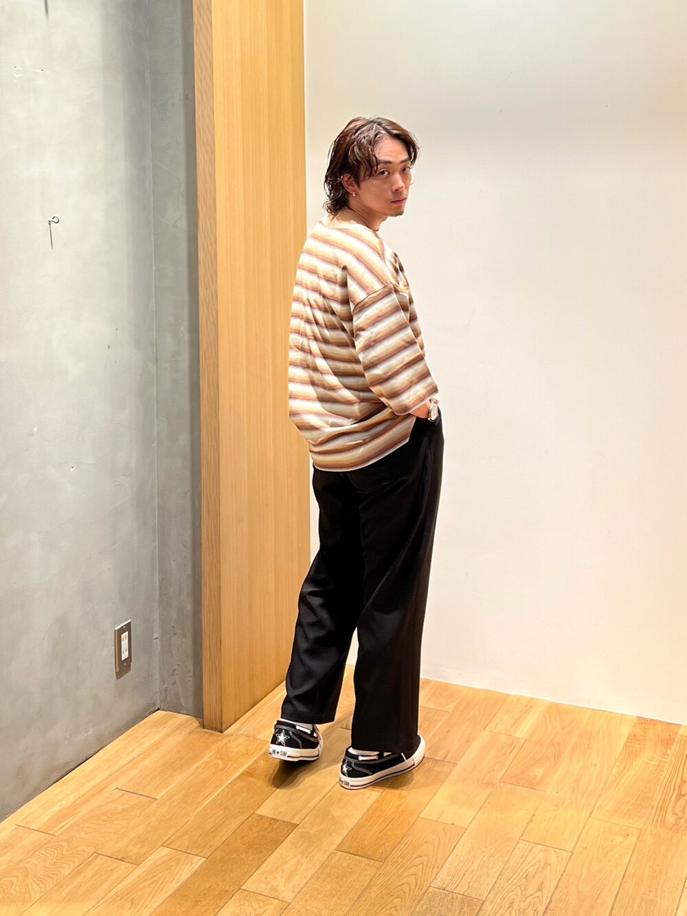 ブラウン系のTシャツ/カットソー、ブラック系のチノパンツ、ブラック系のスニーカーを着用したメンズの夏コーディネートの2枚目の写真
