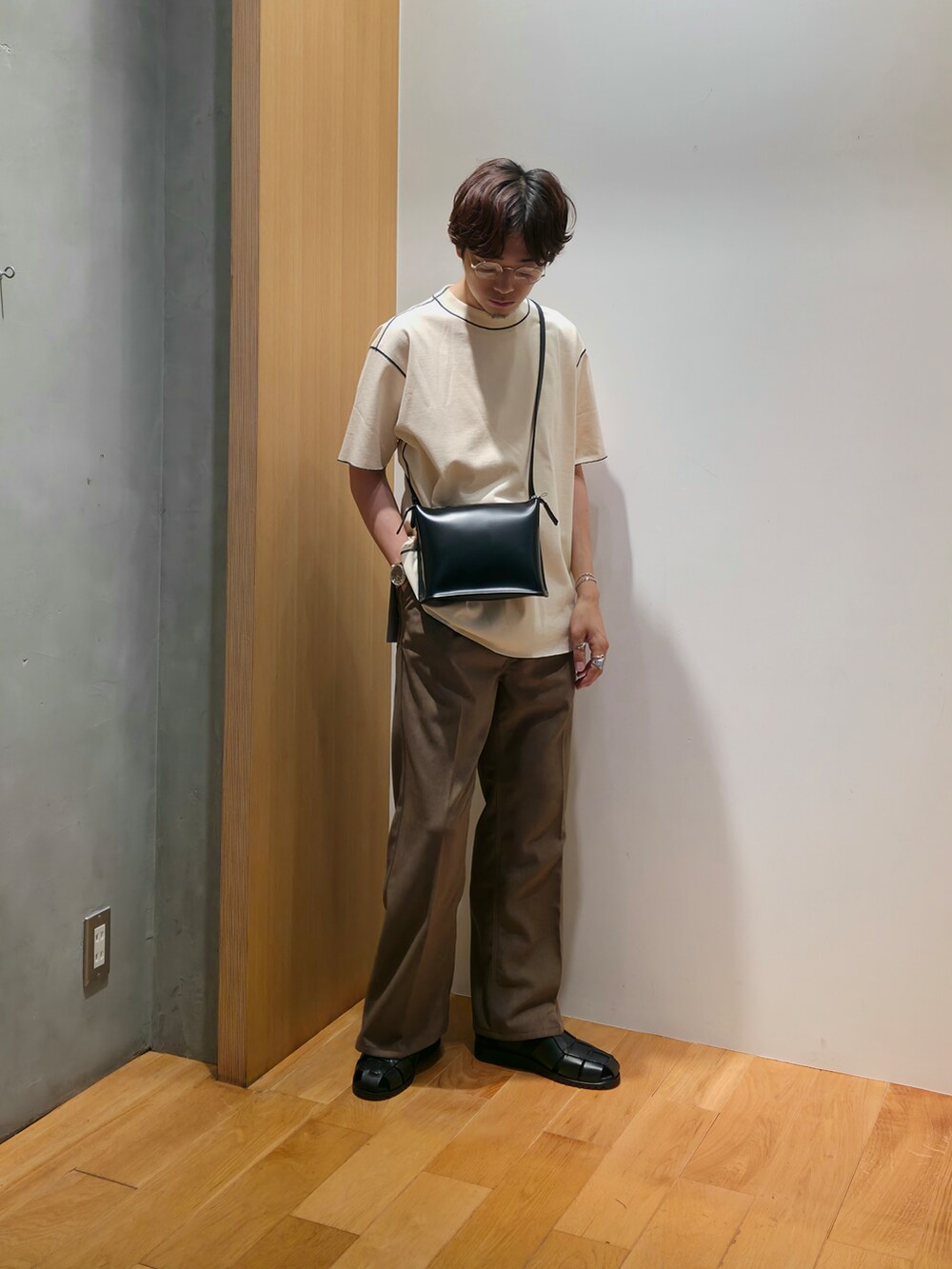 ホワイト系のTシャツ/カットソー、ブラウン系のその他パンツ、ブラック系のサンダルを着用したメンズの夏コーディネートの2枚目の写真