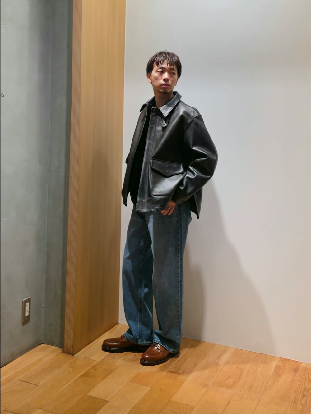 ブラウン系のその他アウター、ブラック系のTシャツ/カットソー、ブルー系のデニムパンツを着用したメンズの秋コーディネートの3枚目の写真