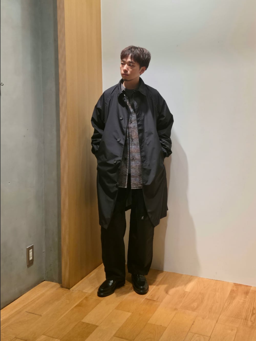 ブラック系のステンカラーコート、グレー系のシャツ/ブラウス、グレー系のTシャツ/カットソーを着用したメンズの秋コーディネートの3枚目の写真