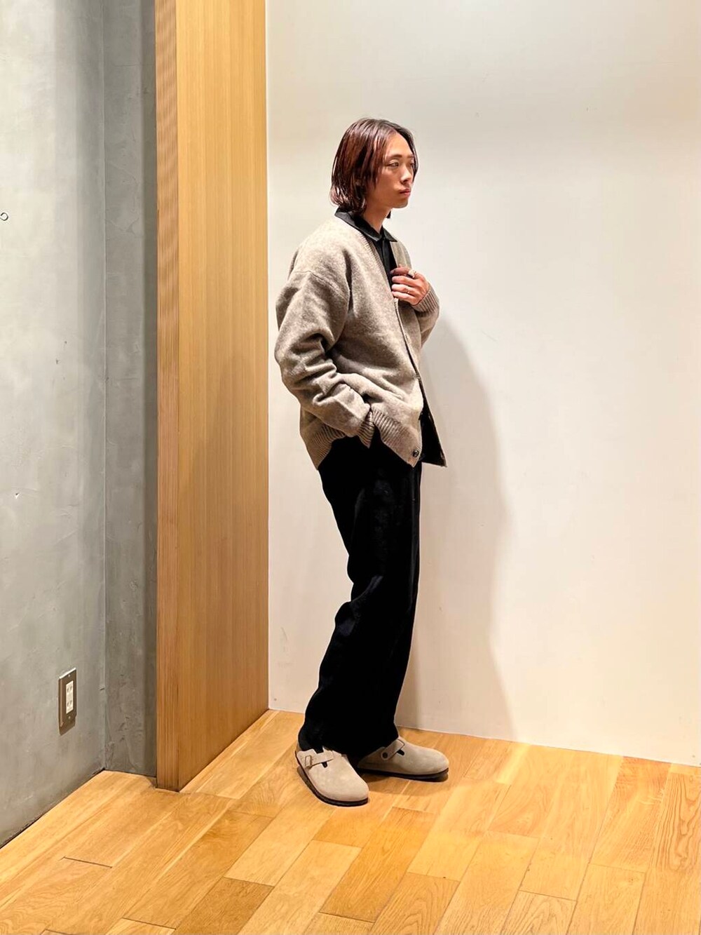 ブラック系のスラックス、グレー系のシャツ/ブラウス、ブラウン系のカーディガン/ボレロを着用したメンズの秋コーディネートの2枚目の写真