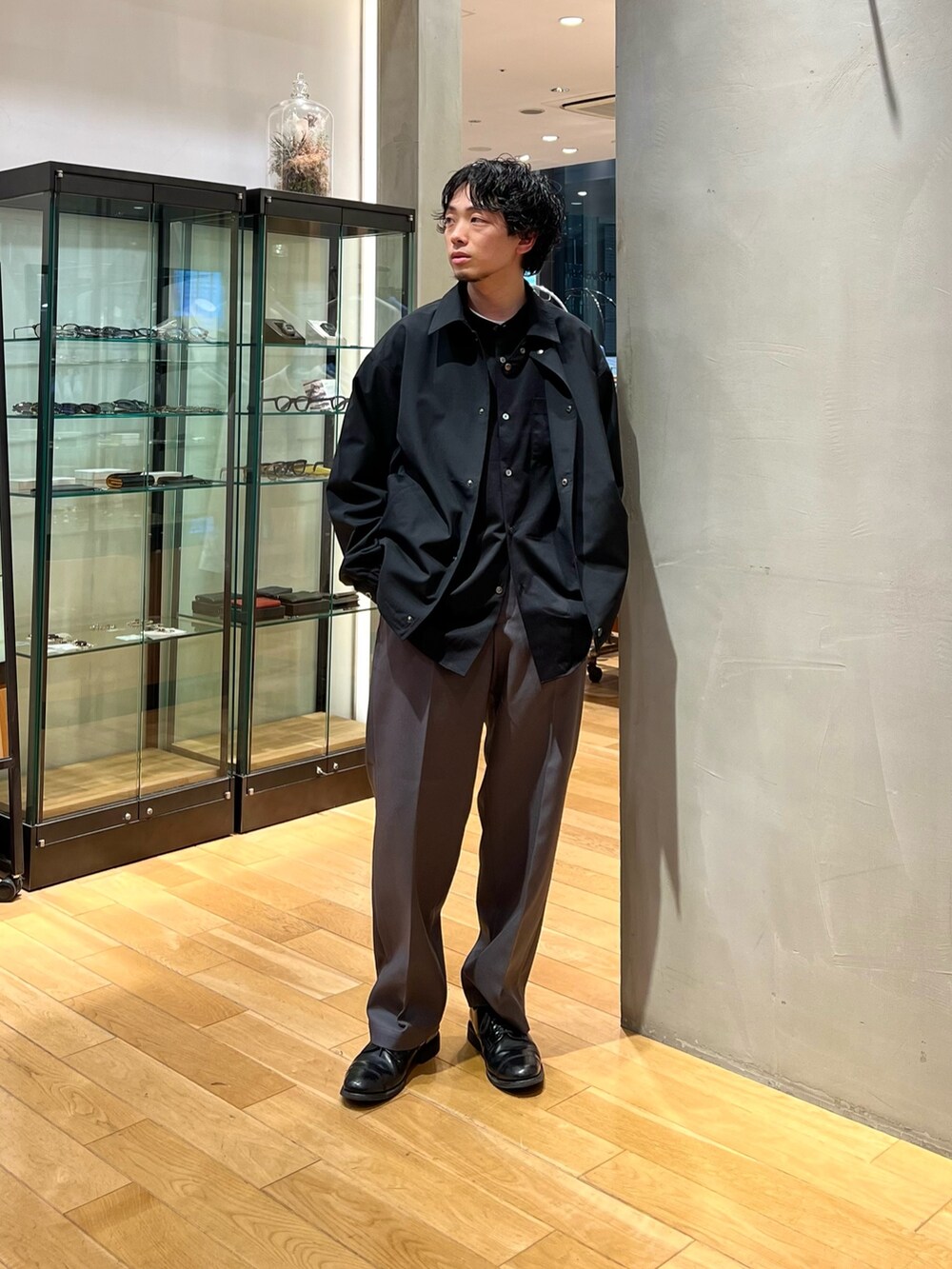 ブラック系のその他アウター、ブラック系のシャツ/ブラウス、グレー系のスラックスを着用したメンズの春コーディネートの2枚目の写真