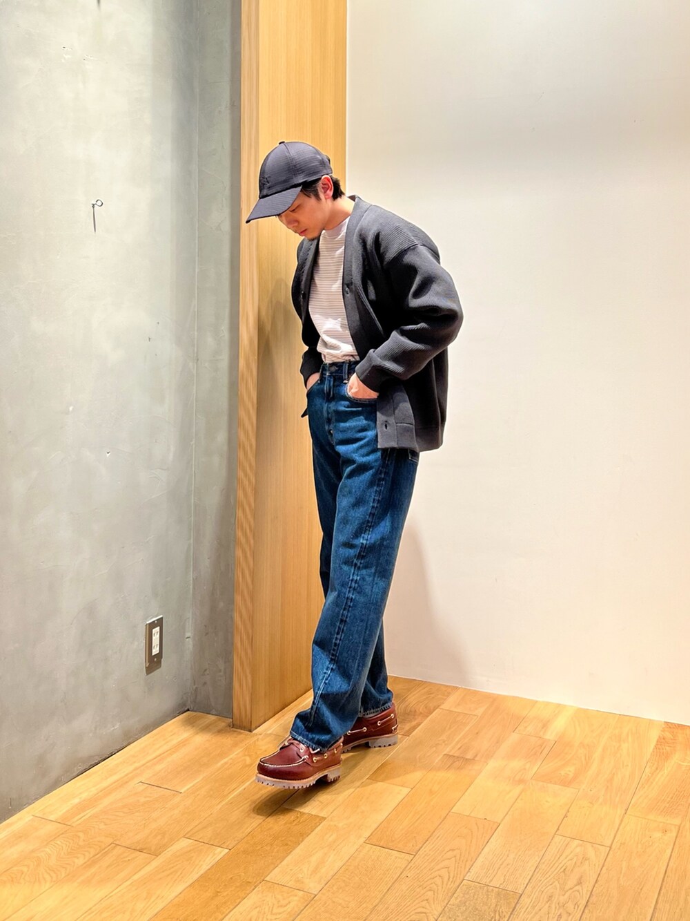 グレー系のTシャツ/カットソー、グレー系のカーディガン/ボレロ、ブルー系のパンツを着用したメンズの冬コーディネートの2枚目の写真