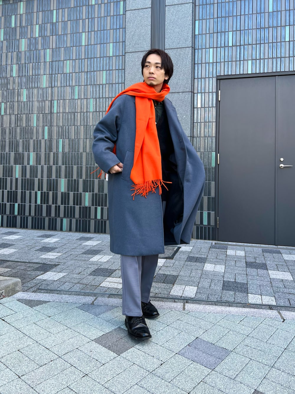 ブルー系のチェスターコート、ブラック系のカーディガン/ボレロ、グリーン系のシャツ/ブラウスを着用したメンズの冬コーディネートの2枚目の写真