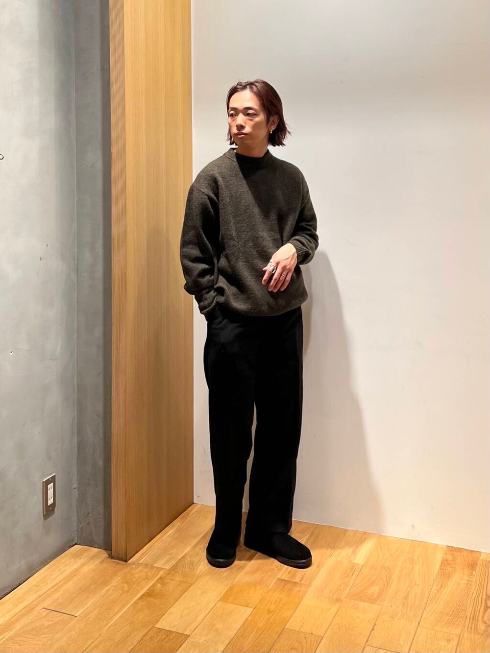 ブラック系のその他パンツ、グリーン系のニット/セーター、ブラック系のブーツを着用したメンズの冬コーディネートの6枚目の写真