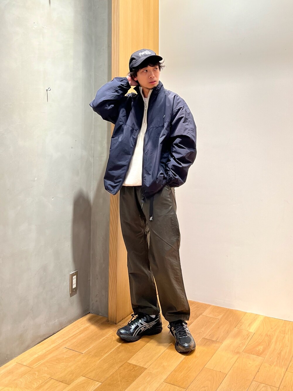 ブラック系のナイロンジャケット、ホワイト系のスウェット、グリーン系のその他パンツを着用したメンズの春コーディネートの3枚目の写真