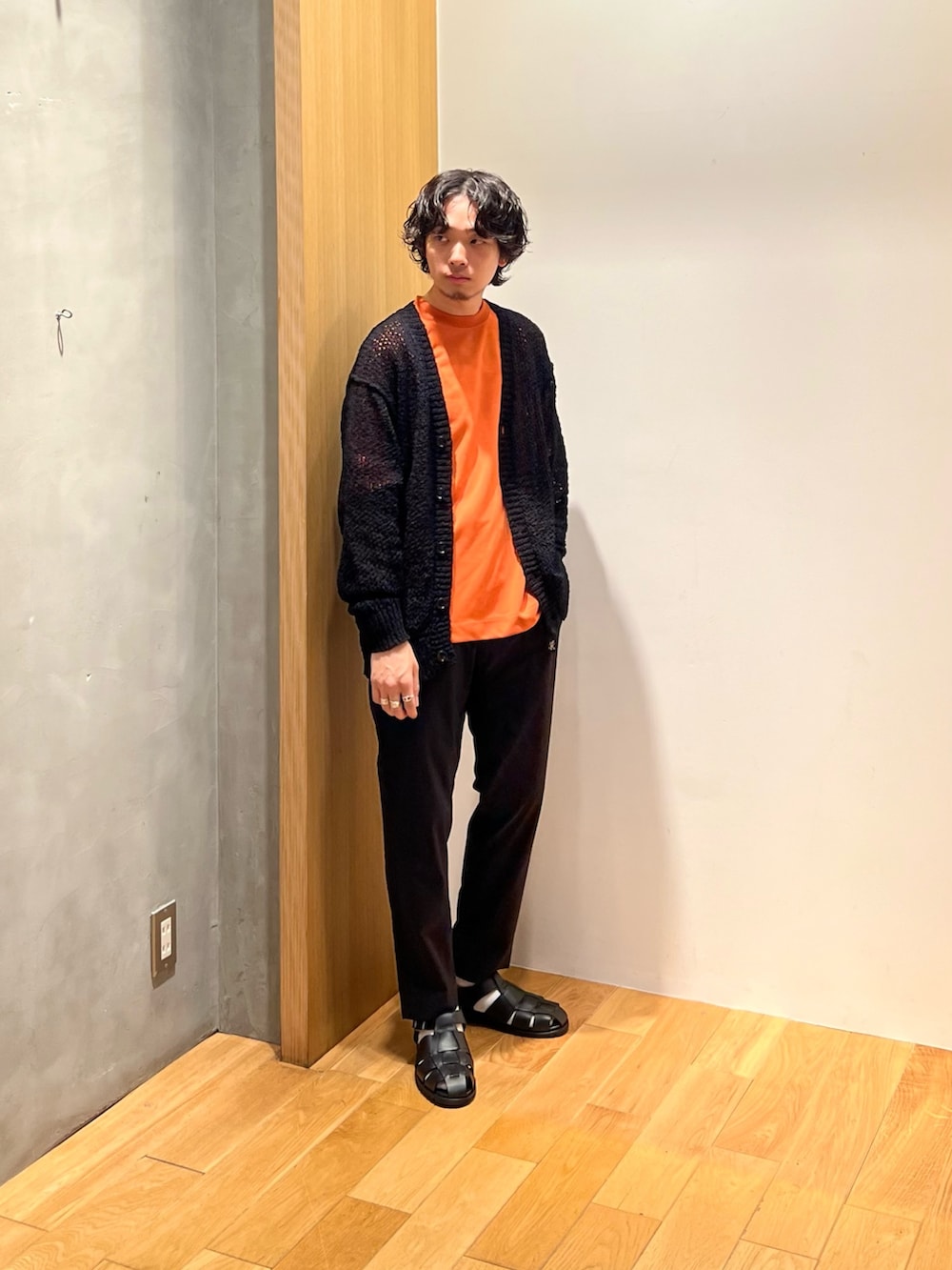 オレンジ系のTシャツ/カットソー、ブラック系のその他パンツ、ブラック系のサンダルを着用したメンズの春コーディネートの3枚目の写真