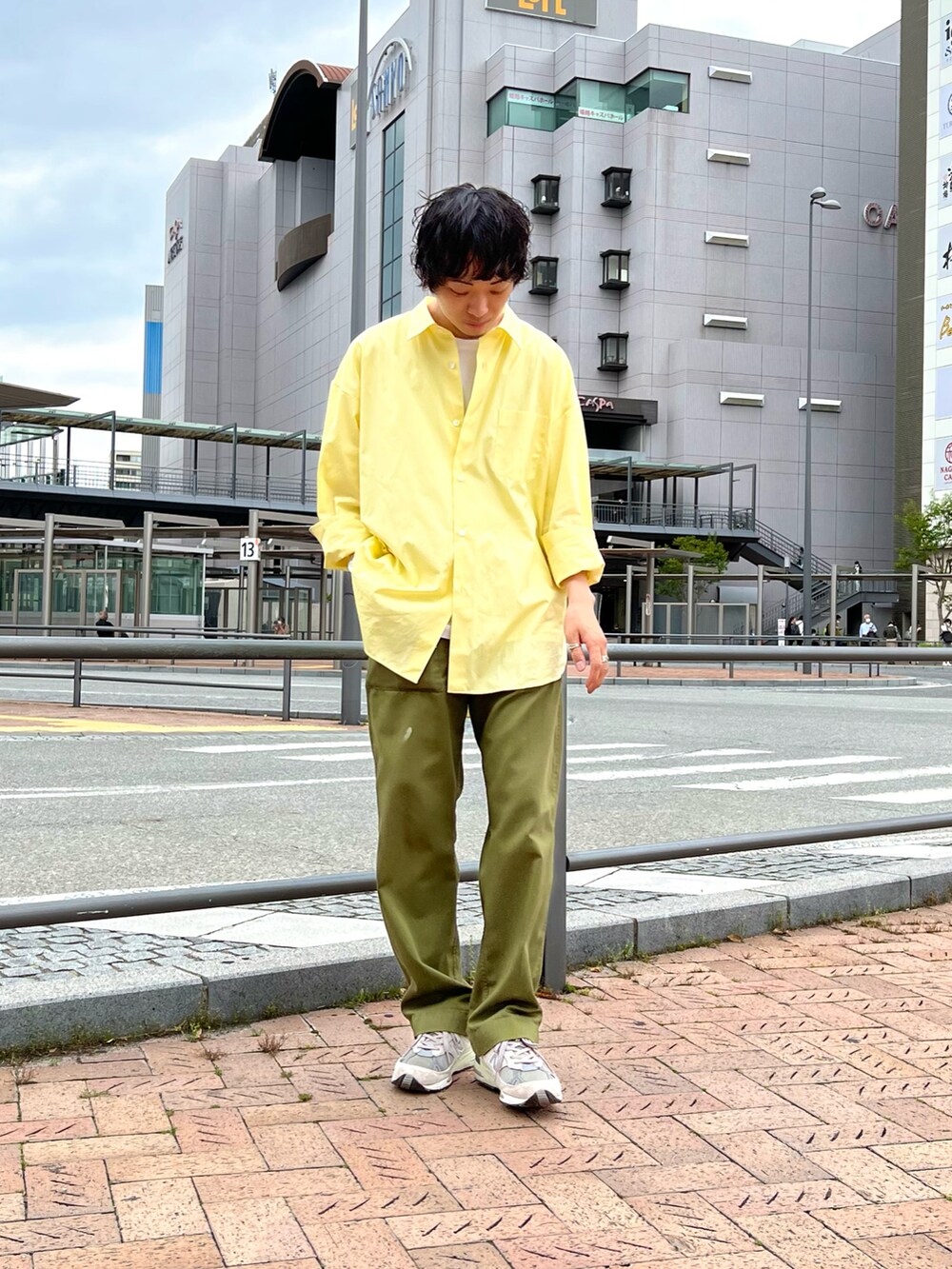 イエロー系のシャツ/ブラウス、ホワイト系のTシャツ/カットソー、グリーン系のパンツを着用したメンズの春コーディネートの2枚目の写真