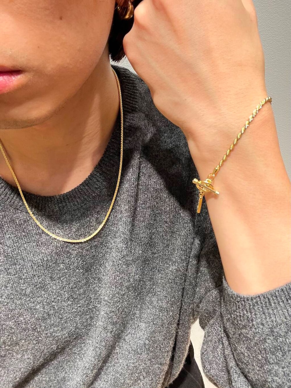 グレー系のニット/セーター、ゴールド系のネックレス、ゴールド系のネックレスを着用したメンズの秋コーディネートの5枚目の写真