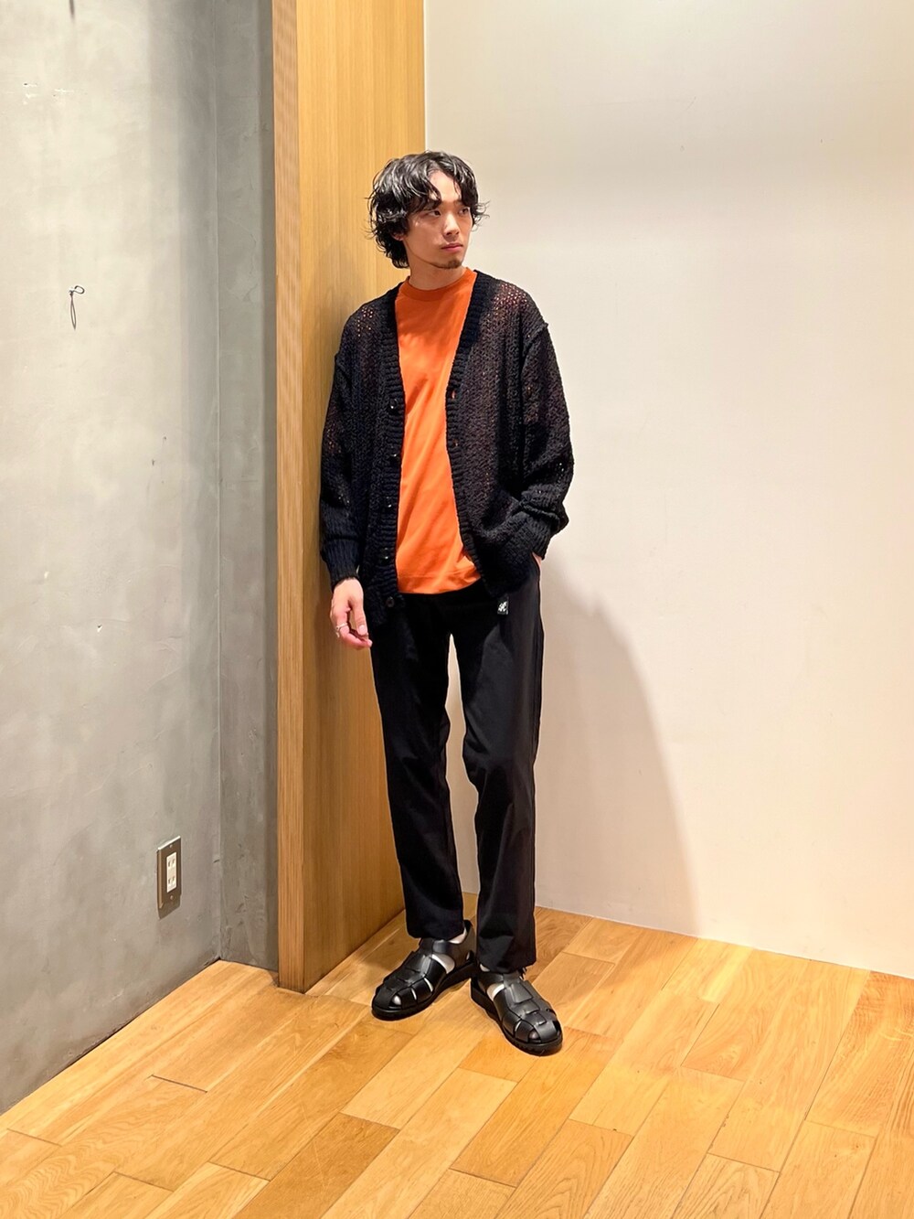 オレンジ系のTシャツ/カットソー、ブラック系のその他パンツ、ブラック系のサンダルを着用したメンズの春コーディネートの2枚目の写真