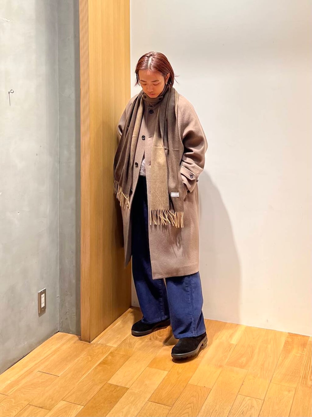 ブラウン系のステンカラーコート、ブルー系のその他パンツ、グレー系のニット/セーターを着用したメンズの冬コーディネートの3枚目の写真