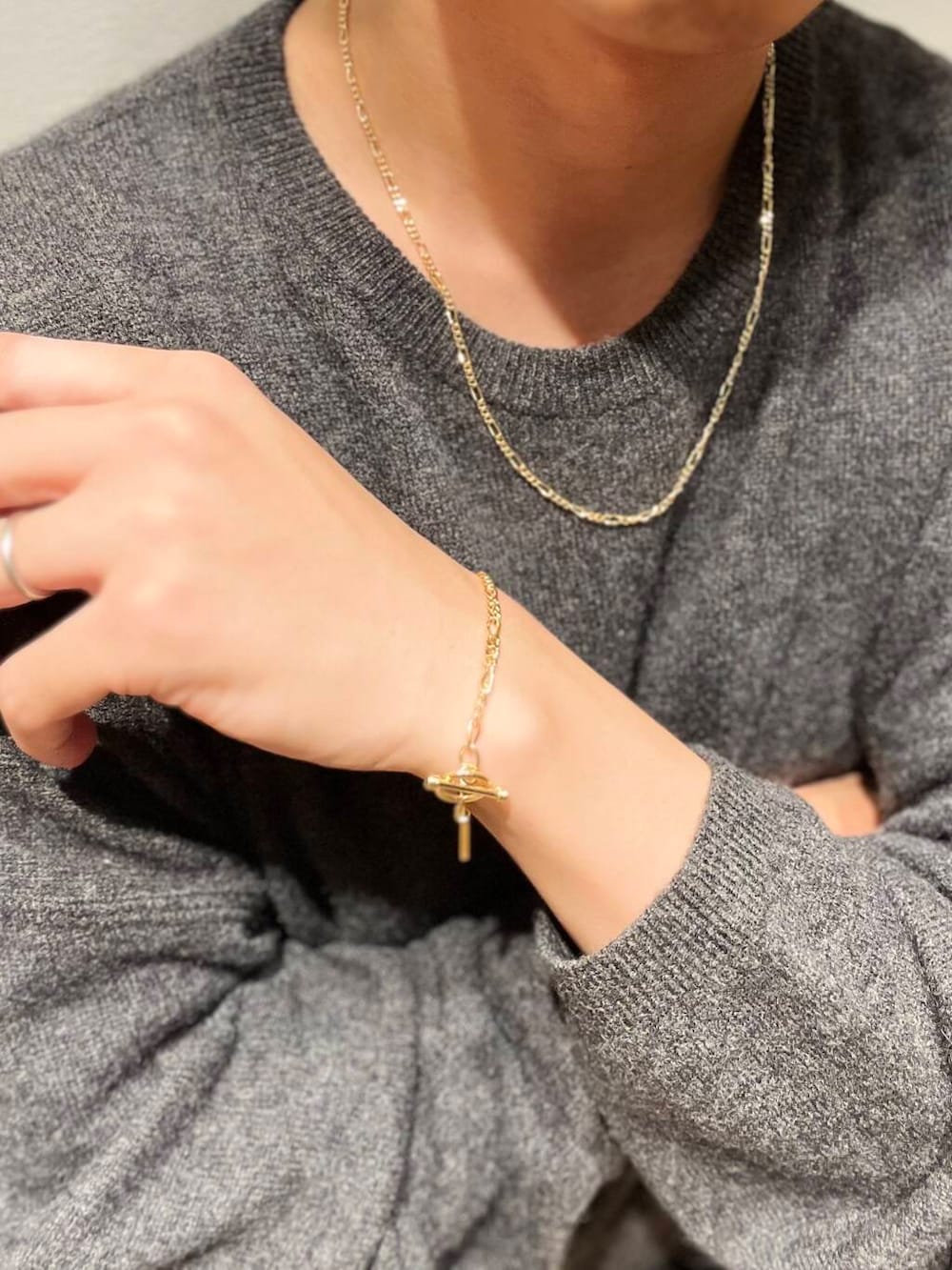 グレー系のニット/セーター、ゴールド系のネックレス、ゴールド系のネックレスを着用したメンズの秋コーディネートの4枚目の写真