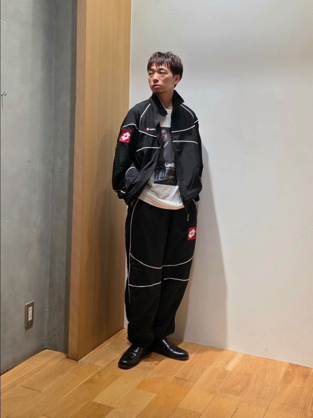 ブラック系のナイロンジャケット、ブラック系のその他パンツ、ホワイト系のTシャツ/カットソーを着用したメンズの秋コーディネートの4枚目の写真