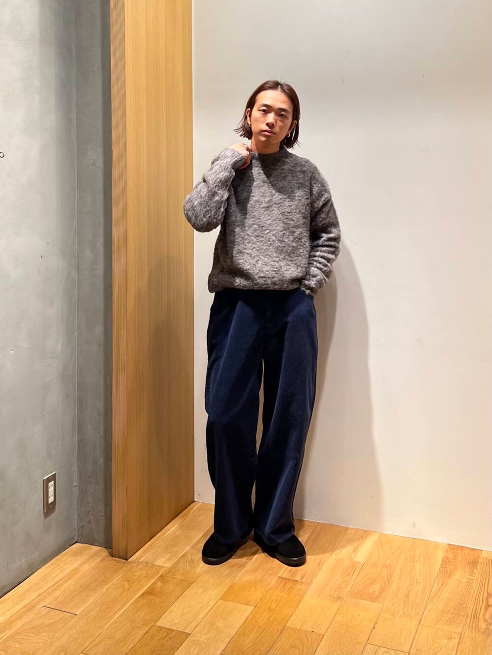 ブラウン系のステンカラーコート、ブルー系のその他パンツ、グレー系のニット/セーターを着用したメンズの冬コーディネートの4枚目の写真