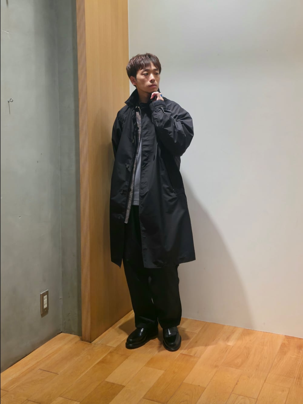 ブラック系のステンカラーコート、グレー系のシャツ/ブラウス、グレー系のTシャツ/カットソーを着用したメンズの秋コーディネートの4枚目の写真