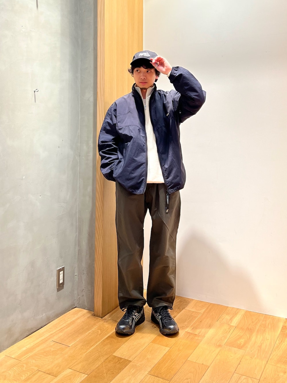 ブラック系のナイロンジャケット、ホワイト系のスウェット、グリーン系のその他パンツを着用したメンズの春コーディネートの2枚目の写真