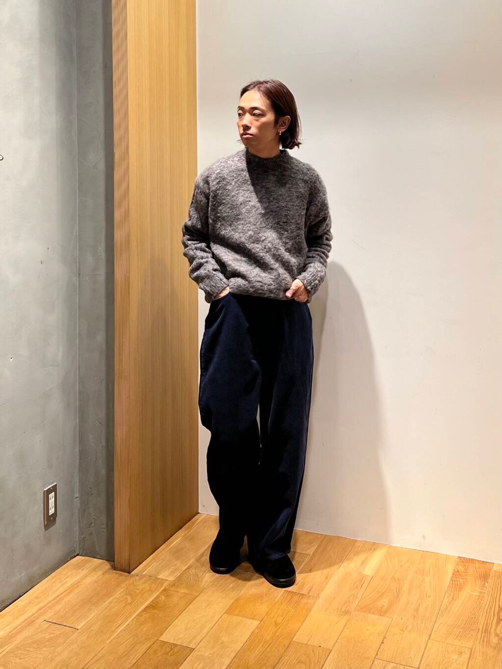 ブラウン系のステンカラーコート、ブルー系のその他パンツ、グレー系のニット/セーターを着用したメンズの冬コーディネートの5枚目の写真