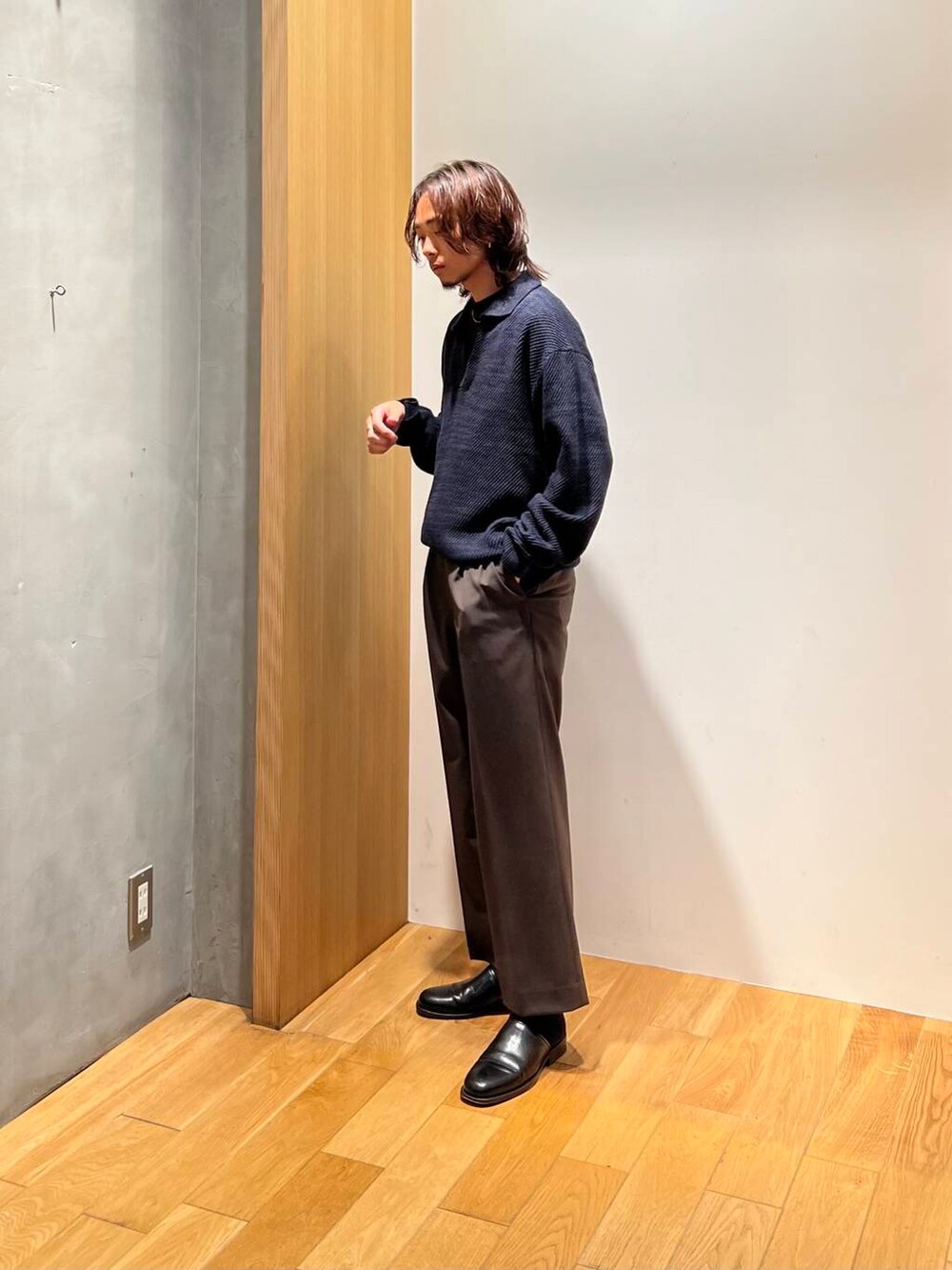 ブラック系のTシャツ/カットソー、ブルー系のニット/セーター、ブラウン系のスラックスを着用したメンズの秋コーディネートの4枚目の写真